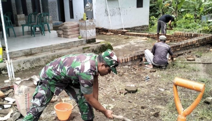 Babinsa Curahdami Bondowoso Turun Tangan Bangun Pagar Balai Desa Sumber Salak
